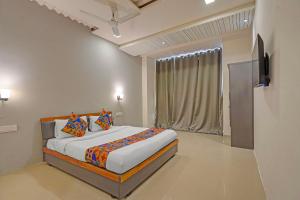un dormitorio con una cama y una ventana en FabHotel Stay In, en Vadodara