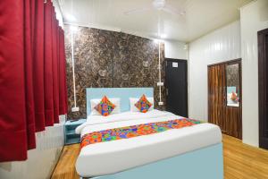 ein Schlafzimmer mit einem großen Bett mit roten Vorhängen in der Unterkunft FabHotel Red Apple in Neu-Delhi