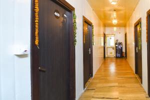 ein Flur mit schwarzen Türen und Holzböden und ein Flur mit in der Unterkunft FabHotel Red Apple in Neu-Delhi