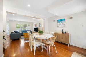 a living room with a table and chairs and a couch at Hazy Shores Escape - Breezy Coastal Stay near Henley Square in Henley Beach