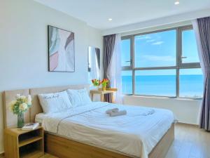 une chambre avec un lit avec une grande fenêtre dans l'établissement The Song Vũng Tàu Luxury Apartment, à Vung Tau 55 autres photos