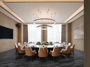 ein Esszimmer mit einem großen Tisch und Stühlen in der Unterkunft Zhangjiagang Wanda Jinhua Hotel 