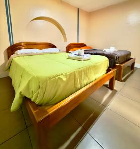 una camera da letto con due letti con lenzuola verdi sopra di Travel Comfort Quito Tourist Hostel a Quito