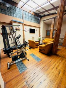 una sala con palestra dotata di tapis roulant e sedie di Travel Comfort Quito Tourist Hostel a Quito