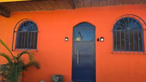 an orange building with a door and two windows at Casita Paraiso Escondido in Peñita de Jaltemba