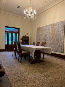 een eetkamer met een tafel, stoelen en een kroonluchter bij Nook Farm in Nagambie