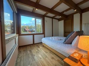 ein Schlafzimmer mit einem Bett und einem großen Fenster in der Unterkunft Niseko Annupuri Royal Chalet in Niseko