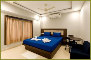 - une chambre avec un lit bleu et une table dans l'établissement Jagannath Temple Hometoun Palace Resort - Fully Air Hotel, à Purî