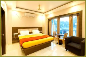 une chambre avec un lit, une chaise et une fenêtre dans l'établissement Jagannath Temple Hometoun Palace Resort - Fully Air Hotel, à Purî