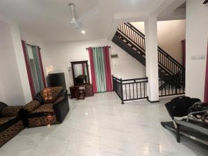 a living room with two chairs and a staircase at Mingu villa in Tangalle