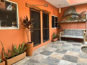a patio with a bench and plants in front of a building at Casa Nawara in Puerto Escondido +31 photos