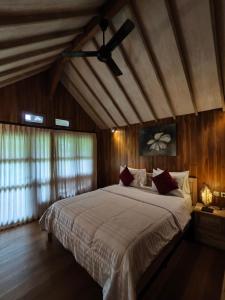 a bedroom with a large bed with a ceiling fan at Tetebatu Flush Harmony in Tetebatu