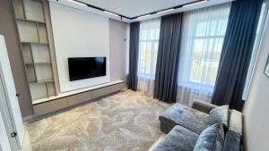 a living room with a couch and a flat screen tv at Апарт-отель Abyroy in Rudny