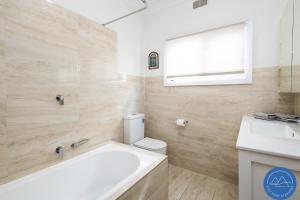 une salle de bain avec une baignoire, des toilettes et un lavabo dans l'établissement Shoal Bay Beach House & Garden Suite - 200m to iconic beach, à Shoal Bay