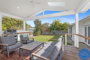 un patio avec une table et des chaises sur une terrasse dans l'établissement Shoal Bay Beach House & Garden Suite - 200m to iconic beach, à Shoal Bay