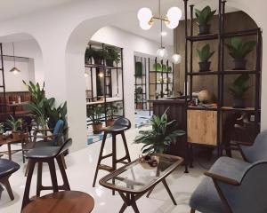 a room with chairs and tables and plants at Fun Hotel in Ban Thai Wat Khot