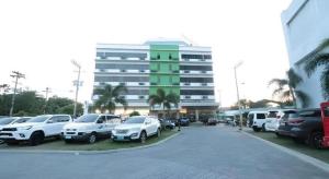 a parking lot with cars parked in front of a building at D' Leonor Hotel in Cabaguio