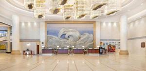 a lobby with a large painting on the wall at Qingdao Haidu Hotel in Huangdao