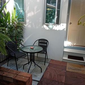 eine Terrasse mit einem Tisch, 2 Stühlen und einer Tür in der Unterkunft Daddy's home Huahin in Hua Hin