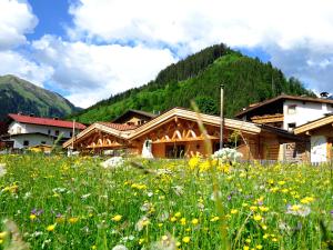 a field of flowers in front of a building at Luxury Chalets Wiesenruh in Bichlbach