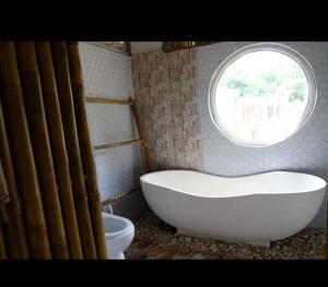 a bath tub in a bathroom with a window at Villa Lakdu in Sorongjukung