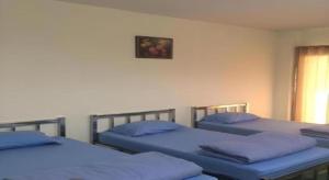 ein Zimmer mit drei Betten mit blauen Kissen in der Unterkunft V.R.Mansion Hotel in Phatthalung + 37 Fotos