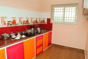 a colorful kitchen with red and orange cabinets at RMP Home Stay in Puducherry