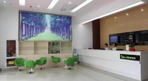 a waiting room with green chairs and a large screen at Vatica Lianyungang Haizhou Xinkong South Road Zhongyin Mingdu Hotel in Yuhang