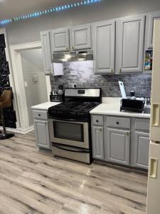 伊丽莎白Huge Elegant condo near EWR and NYC and NJ Transit Unit 1的厨房配有白色橱柜和炉灶烤箱