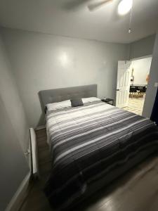 伊丽莎白Huge Elegant condo near EWR and NYC and NJ Transit Unit 1的一间卧室配有带条纹被子的床 更多17张照片