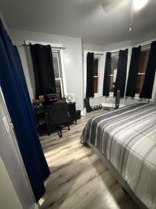 伊丽莎白Huge Elegant condo near EWR and NYC and NJ Transit Unit 1的带床、书桌和窗户的卧室