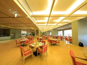 ein Esszimmer mit Tischen und roten Stühlen in der Unterkunft Jeju Booyoung Hotel in Seogwipo