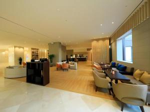 ein großes Wohnzimmer mit Sofas, Tischen und Stühlen in der Unterkunft Jeju Booyoung Hotel in Seogwipo + 158 Fotos