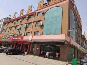 a building on a street with cars parked in front of it at 7 Days Premium Dezhou Qingyun Nanhuan Building Materials Market in Dezhou