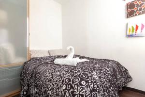 un cisne blanco sentado encima de una cama en Piramides 2 Apartment en Madrid