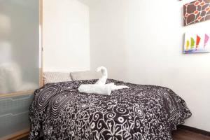 a white swan sitting on top of a bed at Piramides 2 Apartment in Madrid