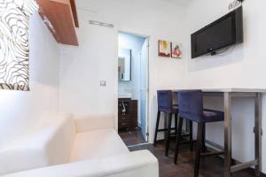 ein Wohnzimmer mit einer weißen Couch und einem Tisch mit Stühlen in der Unterkunft Piramides 2 Apartment in Madrid