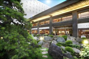 a building with a garden in front of it at Hotel Grand Shinonome in Tsukuba