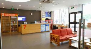 eine Ladenlobby mit einem roten Stuhl und einer Theke in der Unterkunft 7 Days Premium Beijing Dabaotai Metro Station Luhua Road in Peking