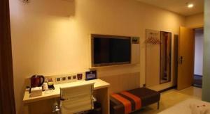 ein Hotelzimmer mit Schreibtisch und Fernseher in der Unterkunft 7 Days Premium Beijing Dabaotai Metro Station Luhua Road in Peking
