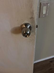 una puerta con un picaporte metálico en una pared en West Phoenix Value Room 5, en Phoenix