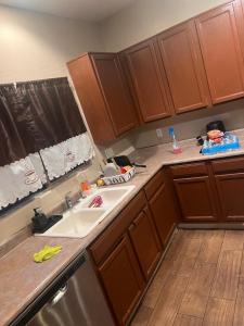 Una cocina con gabinetes de madera y un fregadero. en West Phoenix Value Room 5, en Phoenix 6 fotos más