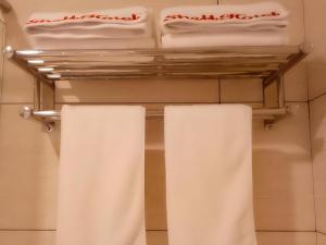 two white towels on a rack in a bathroom at GreenTree Inn Shangrao Qianshan hekou old town Xinjiang longting shell hotel in Shangrao +66 photos