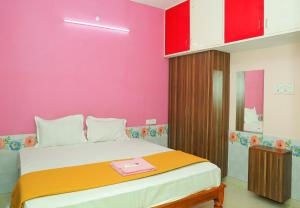 a bedroom with a large bed with a pink wall at RMP Home Stay in Puducherry