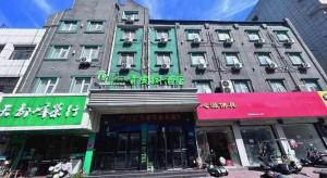 a large building on a city street with buildings at Vatica JiangsuJianguo Road Xuanwu Market Hotel in Xuzhou