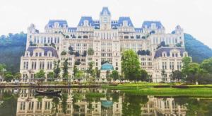 a large white building with its reflection in the water at Xana Lite Guiyang Huaguoyuan Shuangzi Towers in Guiyang