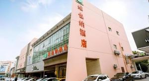 a pink building with cars parked in front of it at Vienna Suzhou Oriental Gate Jinji Lake in Suzhou