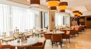 a restaurant with white tables and chairs and windows at Jinjiang Inn Select Hohhot Chengjisihan Square Metro Station in Hohhot