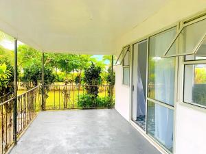 eine leere Veranda eines Hauses mit Glastüren in der Unterkunft Private Double Room - Airport Cottage in Fua‘amotu