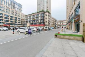 eine Straße in einer Stadt mit Autos und Gebäuden in der Unterkunft Xana Hotelle Chengdou Xindu Sanhechang Metro Station in Chengdu